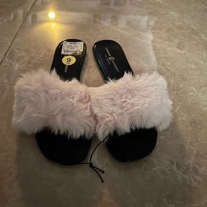 Black slipper with white fur on top